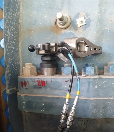 Hydraulic bolt tensioner tool attached to a flange joint
